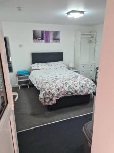 a small bedroom with a bed and a dresser at Cosy Studio - Town centre flat with free nearby parking in Shrewsbury
