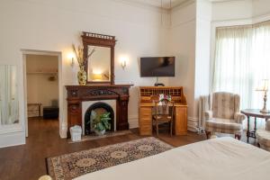 a living room with a fireplace and a television at Hochelaga Inn in Kingston
