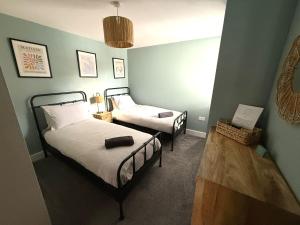 two beds in a room with green walls at X-Large two bedroom & two bathroom apartment with free evening parking in Southampton