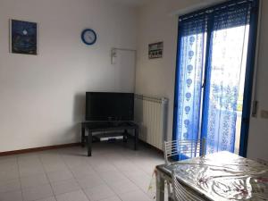 a living room with a flat screen tv and a table at Casa Vacanza Azzurra 2 in Fano