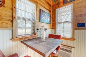 a wooden table in a room with two windows at Red Cabin on the Ranch in Harper