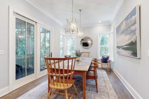 a dining room with a table and chairs and windows at The Ocean Hideaway in Seabrook Island