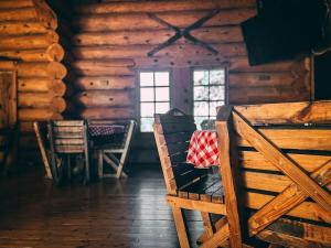 a room with a table and chairs in a log cabin at ÖBois Charlevoix - L'Écurie 4 Studio in Saint-Siméon