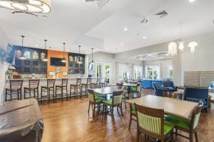 a restaurant with tables and chairs and a bar at Millville By The Sea in Millville