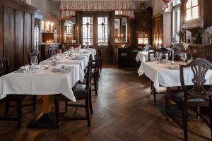 a dining room with tables with white tablecloths at Hotel Weisses Haus in Bad Kissingen