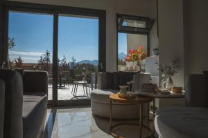 a living room with couches and a view of a patio at Alkyonis Hotel & Spa in Kato Loutraki