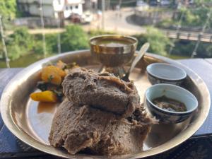 MirikにあるSadnas Homestay Mirikのテーブルの上に置かれた食べ物の皿