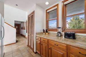 a kitchen with a counter with a microwave and windows at Woodrun Place 56 in Snowmass +80 photos