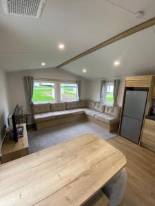 a living room with a couch and a table at 3 Bedroom - Stunning Caravan in Coastal Eyemouth in Eyemouth