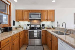 a kitchen with wooden cabinets and a stove top oven at Woodrun Place 56 in Snowmass