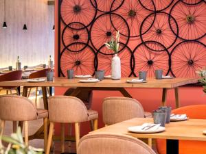 a restaurant with tables and chairs and a wall with umbrellas at Mercure Porto Centro Santa Catarina in Porto