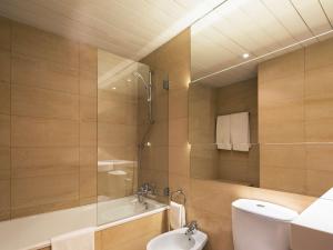 a bathroom with a shower and a toilet and a sink at Mercure Porto Centro Santa Catarina in Porto