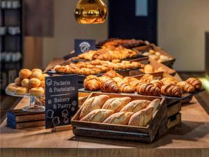a display of bread and pastries on a table at Mercure Porto Centro Santa Catarina in Porto