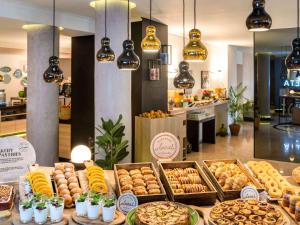 a buffet with various types of bread and pastries at Mercure Porto Centro Santa Catarina in Porto