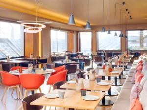 a restaurant with tables and chairs and windows at Mercure Porto Centro Santa Catarina in Porto
