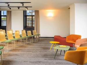a waiting room with colorful chairs and tables at Mercure Porto Centro Santa Catarina in Porto