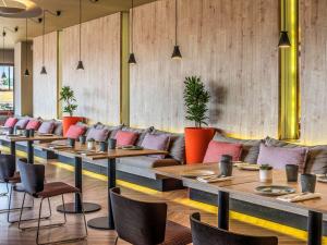 a row of tables and chairs in a restaurant at Mercure Porto Centro Santa Catarina in Porto