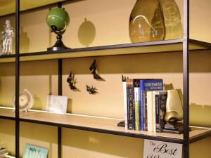 a book shelf with books and butterflies on it at Mercure Porto Centro Santa Catarina in Porto