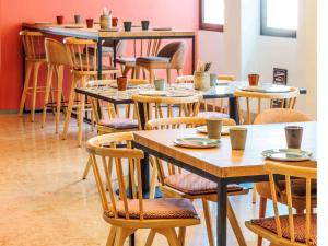 a row of tables and chairs in a restaurant at Mercure Porto Centro Santa Catarina in Porto