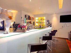 a bar in a store with stools and a counter at Mercure Porto Centro Santa Catarina in Porto