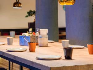 a wooden table with plates and cups on it at Mercure Porto Centro Santa Catarina in Porto