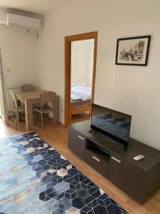 a living room with a flat screen tv on a dresser at Pastel apartment in Skopje