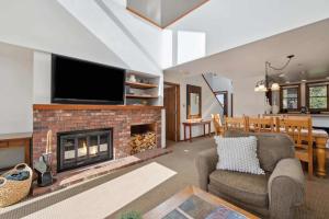 a living room with a fireplace and a tv at Woodrun Place 56 in Snowmass