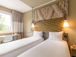 Cama ou camas em um quarto em ibis Genève Aéroport