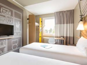 Cama ou camas em um quarto em ibis Genève Aéroport