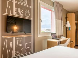 Uma TV ou centro de entretenimento em ibis Genève Aéroport