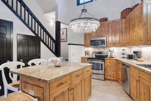 a large kitchen with wooden cabinets and a chandelier at Woodrun Place 36 in Snowmass