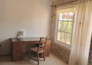 a desk with a chair next to a window at Casa Sagittarius Ocean view in San Marcos