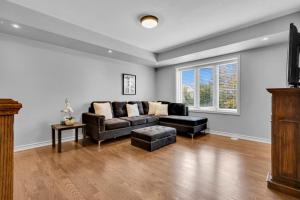 a living room with a couch and a table at Cozy 3BR Home with Parking Near Kitchener Attractions in Kitchener