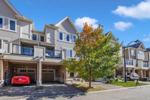 a house with a red car parked in front of it at Cozy 3BR Home with Parking Near Kitchener Attractions in Kitchener