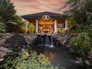 a pond in front of a house with a water fountain at Sofitel Fiji Resort & Spa in Denarau