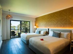 a hotel room with two beds and a balcony at Sofitel Fiji Resort & Spa in Denarau