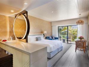 a bedroom with a bed and a sink and a mirror at Sofitel Fiji Resort & Spa in Denarau
