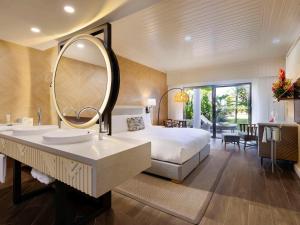 a bedroom with a bed and a large mirror at Sofitel Fiji Resort & Spa in Denarau