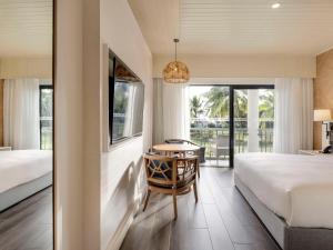 a bedroom with a bed and a desk and a table at Sofitel Fiji Resort & Spa in Denarau