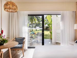 a dining room and living room with a table and chairs at Sofitel Fiji Resort & Spa in Denarau