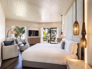 a bedroom with a large bed and a living room at Sofitel Fiji Resort & Spa in Denarau