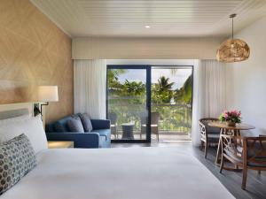 a bedroom with a bed and a living room at Sofitel Fiji Resort & Spa in Denarau
