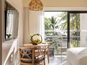 a room with a table with a bowl of fruit on it at Sofitel Fiji Resort & Spa in Denarau