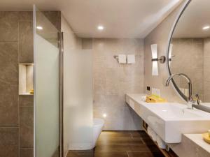 a bathroom with a shower and a sink and a toilet at Sofitel Fiji Resort & Spa in Denarau