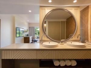 a bathroom with two sinks and a large mirror at Sofitel Fiji Resort & Spa in Denarau