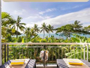 a balcony with a view of the ocean and palm trees at Sofitel Fiji Resort & Spa in Denarau