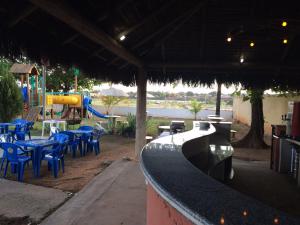 a bar with blue chairs and a playground at Hotel Canoeiros in Pirapora
