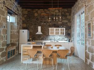 a kitchen with a table and chairs in a room at Casa Bailarina, romantický kamenný dům s úžasným výhledem na oceán in Agaete