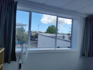 Una habitación con ventana con ventilador y vista. en 4 Beds including 1 Double Bed, 1 Single Beds, 2 Double Sofa Beds, Suite 2, 37 Totara Avenue, New Lynn, en Auckland 3 fotos más
