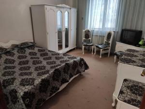 Un dormitorio con una cama, una cómoda y un televisor. en Sweet Family Home in Yerevan, en Ereván